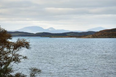 Crinan yakınlarındaki kayalık kıyıların, uçurumların, tepelerin, dağ tepelerinin ve ormanlık alanların panoramik hava manzarası. Argyll ve Bute, İskoçya, İngiltere. Dramatik bulut manzarası. Seyahat yerleri, turizm teması