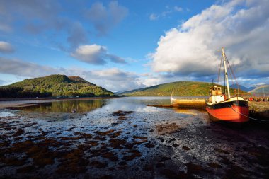 Loch Fyne yakınlarındaki sahil, orman ve tepelerin manzarası. Kırmızı balıkçı teknesi. Inveraray, Inner Hebrides, Argyll ve Bute, İskoçya, İngiltere