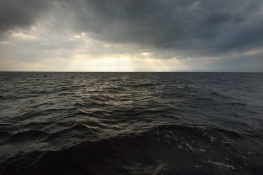 Norveç 'te fırtınadan sonra kuzey denizi. Parlayan kümülüs bulutlarıyla dramatik günbatımı gökyüzü. Destansı bulut manzarası. Yelkenli teknenin manzarası. Meteoroloji, kasırga, iklim değişikliği, mevsimler