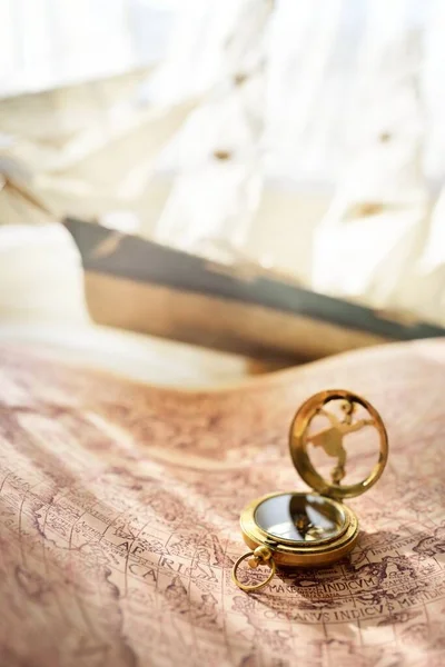 レトロなスタイルの黄金のアンティークコンパス 日時計 木製の背の高い船のスケールモデルと古い白い海図をクローズアップ ヴィンテージはまだ生きてる セーリング ナビゲーションの概念 お土産 贈り物 — ストック写真
