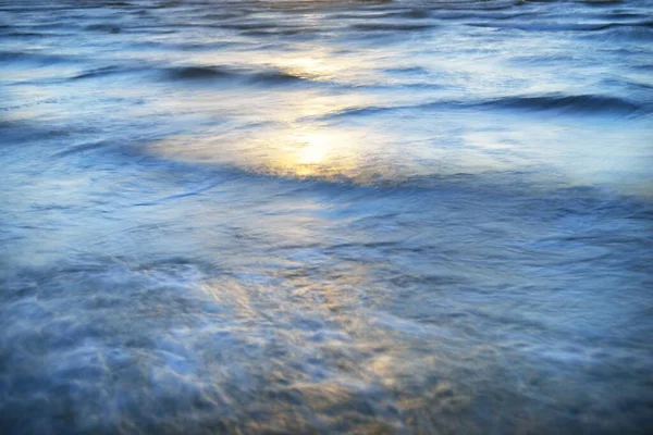 海浪和飞溅的纹理 五彩斑斓的天空映在水面上 Idyllic海景 概念形象 长期暴露 风景如画 自然图案 图形资源 — 图库照片