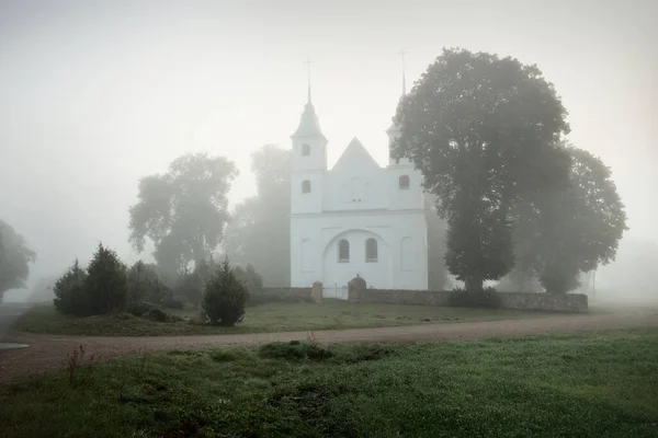 厚い神秘的な霧の中で 古い白い伝統的なカトリック教会 クローズアップ 旅行先 国のランドマーク 文化と宗教 カトリック キリスト教 — ストック写真