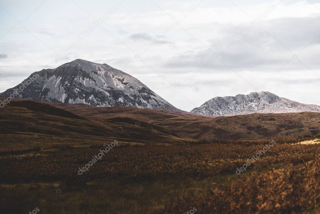 Panoramic view of the valley near the highest mountain peak of Paps of Jura (Beinn an ir) under the dark storm sky. Dramatic clouds. Jura island, Inner Hebrides, Scotland, UK. Atmospheric landscape.