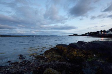 Göl kıyılarının panoramik manzarası, vadiler, tepeler ve ormanlar süs dolu fırtınalı bulutlar altında. Alacakaranlık gökyüzü. Ardrishaig, Crinan Kanalı, İskoçya, İngiltere. Doğa, ekoloji, çevre koruma