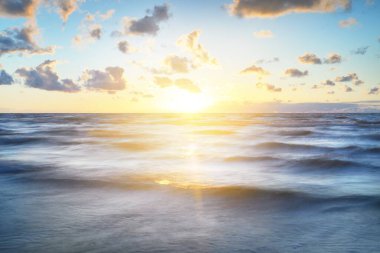 Gök gürültülü bir fırtınadan sonra denizin üstünde destansı pembe gün batımı bulutları. Dramatik bir gökyüzü. Dalgalar ve su dokuya sıçrar. Idyllic deniz manzarası. Kavramsal görüntü, uzun pozlama. Resim gibi bir manzara.