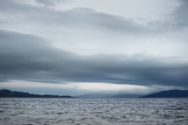 Bulutlu bir sonbahar günü. Sudan Tarbert kıyılarının manzarası. Karanlık fırtına gökyüzü. İskoçya, İngiltere