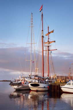 Yelkenliler bir rıhtıma demirlemiş, yakın plan. Gün doğumunda küçük bir kasaba olan Port Ellen 'ın sahili. Islay Adası, Inner Hebrides, İskoçya, İngiltere