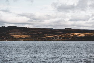 Dramatik gökyüzü altında Tarbert 'in kayalık kıyılarının panoramik manzarası. İskoçya, İngiltere. Seyahat yerleri, ulusal dönüm noktası, eğlence, eko turizm, tatiller, macera, keşif