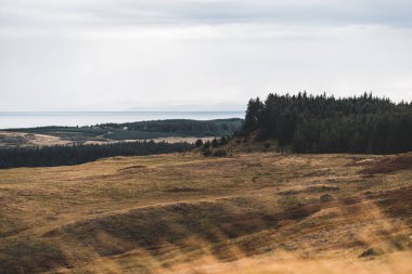 Jura adasının kıyıları, dağları ve vadilerinin panoramik hava manzarası. Bulutlu mavi gökyüzü. Fırtınalı hava. Paps of Jura, Inner Hebrides, İskoçya, İngiltere. Seyahat yerleri, turizm, ulusal simgeler