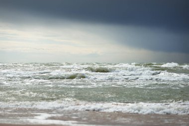 Fırtına sonrası karanlık dramatik bulutların altında Baltık Denizi. Letonya 'da sızıntı var. Destansı deniz manzarası. Kasırga, fırtına, sert hava, meteoroloji, ekoloji, iklim değişikliği, doğal olaylar