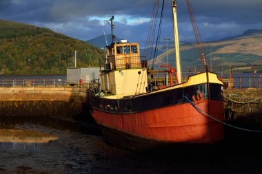Loch Fyne yakınlarındaki sahil, orman ve tepelerin manzarası. Kırmızı balıkçı teknesi. Inveraray, Inner Hebrides, Argyll ve Bute, İskoçya, İngiltere