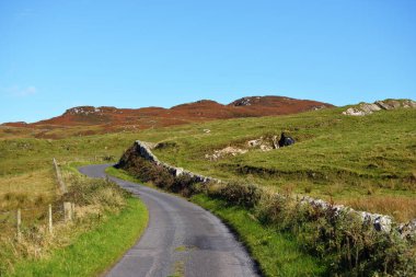 Islay Adası 'nın vadi ve tepelerinden geçen boş viraj yolu. Panoramik manzara. Inner Hebrides, İskoçya, İngiltere. Seyahat yerleri, ulusal simgeler. Eğlence, çevre koruma
