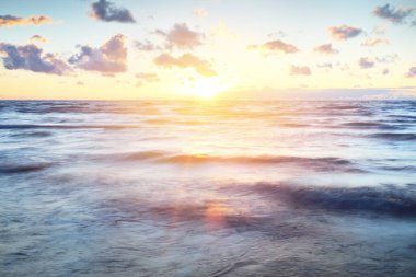 Gök gürültülü bir fırtınadan sonra denizin üstünde destansı pembe gün batımı bulutları. Dramatik bir gökyüzü. Dalgalar ve su dokuya sıçrar. Idyllic deniz manzarası. Kavramsal görüntü, uzun pozlama. Resim gibi bir manzara.