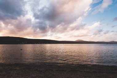 Yağmurdan sonra fırtınalı akşam gökyüzünün altında Rocky Gölü kıyısı. Dramatik gün batımı bulutları. Gare Loch, Rhu, İskoçya, İngiltere. Seyahat yerleri, tatiller, boş zaman aktivite kavramları
