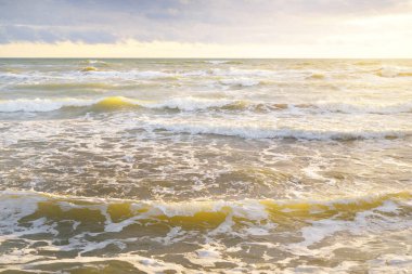 Gün batımında fırtınadan sonra Baltık Denizi. Letonya 'da sızıntı var. Renkli parlayan bulutlar. Dalgalar ve su sıçramaları. Destansı deniz manzarası. Kasırga, fırtına, dönek hava, meteoroloji, ekoloji