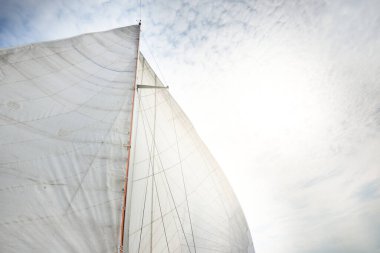 Bulutlu mavi gökyüzüne karşı donanımlı bir yatın beyaz yelkenlileri. Yelkencilik ve donanım. Eğlence teması. Kuzey denizi, Norveç