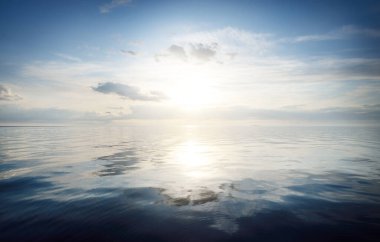 Gün batımında Baltık Denizi 'nin üzerinde açık mavi gökyüzü ve kümülüs bulutları. Idyllic deniz manzarası. Seyahat, yelken, gezi, eğlence, tatil. Sudaki simetri yansımaları, doğal ayna.