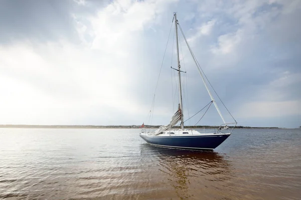 Niebieski Sloop Uzbrojony Jacht Zakotwiczony Płytkiej Wodzie Pobliżu Piaszczystego Brzegu — Zdjęcie stockowe