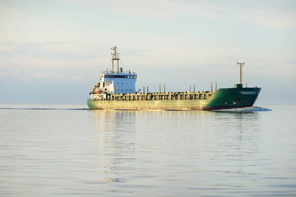 日落时在开阔海上航行的大型绿色货船 多彩的云彩 温暖的阳光 概念形象 货物运输 全球通信 — 图库照片