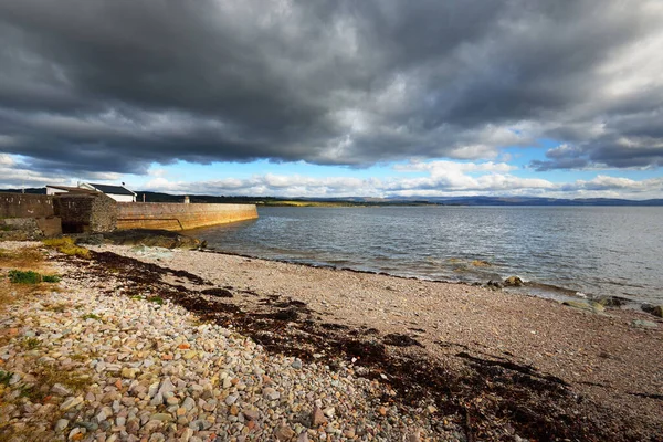Eski deniz fenerine boş bir gezinti alanı, çakıllı plaj yakınlaşması. Dramatik bulut manzarası. Ardrishaig, Crinan Kanalı, İskoçya, İngiltere. Seyahat yerleri, gezi teması