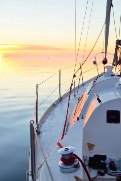 日落时 白色游艇在开阔的海面上航行 从甲板到船头的近景 清澈的蓝天 明亮的粉色云彩反射在平静的水中 Idyllic海景 旅游目的地 — 图库照片