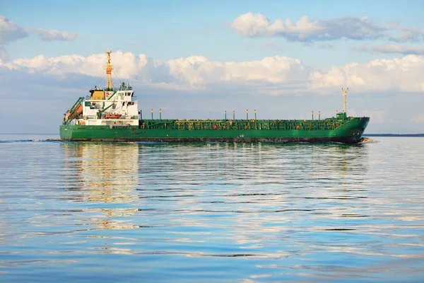 日没時には大規模な緑の貨物船が外洋を航行する カラフルな輝く雲 暖かい日差し コンセプトイメージ 貨物輸送 ビジネス グローバル通信 — ストック写真