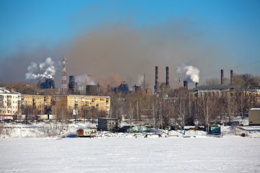 Nizhny Tagil, Rusya Federasyonu - 16 Şubat 2016: Duman ve konut bir arka plan üzerinde bir borudan Buhar. Perednm plan - gölet karla kaplı. Nizhny Tagil, orta Urallar en büyük sanayi merkezi.