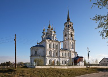 Severouralsk, Rusya - 20 Mayıs 2016: Üç katlı, çan kulesi olan beyaz bina ve üzerinde haç olan trehyarusnoy altın kubbeleri. Peter ve Paul Church - Severouralsk şehrindeki Ortodoks Kilisesi. 1787 ve 1798 yılları arasında inşa edilmiş..