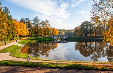 Gölette yansıması olan sonbahar parkı sahnesi  