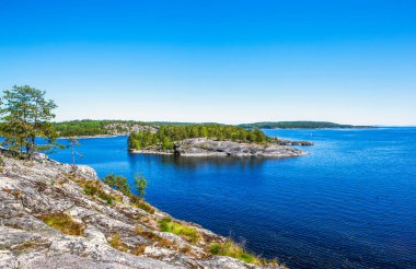 Baykal sularındaki küçük kayalık adanın mavi gökyüzü ve parlak güneş ışığı manzarası