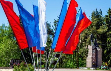 Mavi, kırmızı ve beyaz bayraklar parlak güneş ışığında duruyor