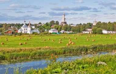 Saman ruloları ve Kamenka nehri ile Suzdal 'ın manzarasına karşı bir tarlanın manzarası. Vladimir bölgesi. Altın yüzük. - Rusya. Tarih 2 Ağustos 2017.
