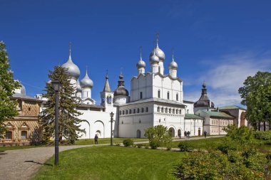 İnsanlar aydınlık gün ışığında kilise binasının önünden geçiyorlar.