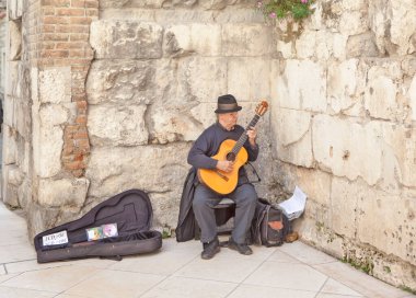BÖLÜM, CROATIA - Mayıs 03, 2019: Eski kasabadaki sokak müzisyeninin fotoğrafı.