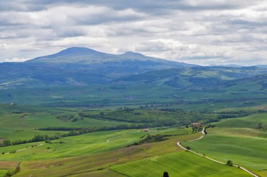 Bulutlu gökyüzü ile yemyeşil dağ manzarası