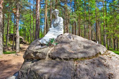 Güneşli ormanlarda kayadaki kadın heykeli