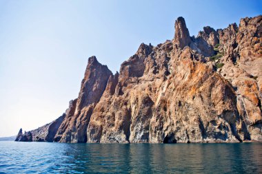 Kara Dag parlak güneş ışığında denizin üzerinde sallanıyor.