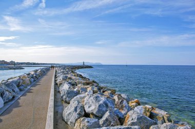 Yürüme alanı olarak taş ve beton levhalardan yapılmış bir iskele. San Vincenzo 'da. İtalya. Çekim tarihi 16 Eylül 2018