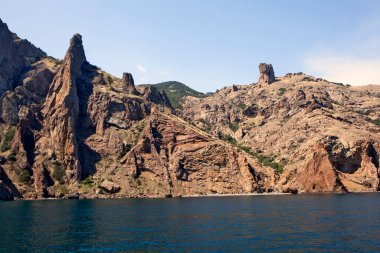 Kara Dag parlak güneş ışığında denizin üzerinde sallanıyor.