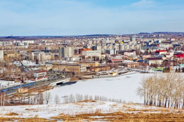  Kar ve fabrika borularıyla kaplı donmuş göl manzaralı Nizhny Tagil.