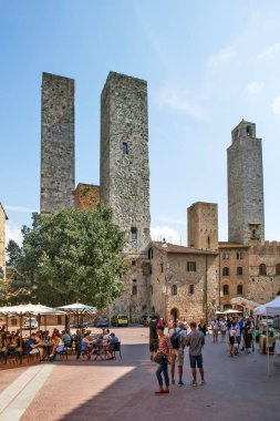 SAN GIMIGNANO, ITALY - 15 Eylül 2018: Torri dei Salvucci 'nin fotoğrafı - ikiz kuleler, Torre Ronoza, veya Saat Kulesi veya Piazza del Duomo veya Katedral Meydanı üzerindeki Podesta Kulesi