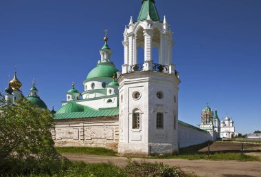 Çan kulesi ve parlak güneş ışığı altında kiliseleri olan manastır duvarı