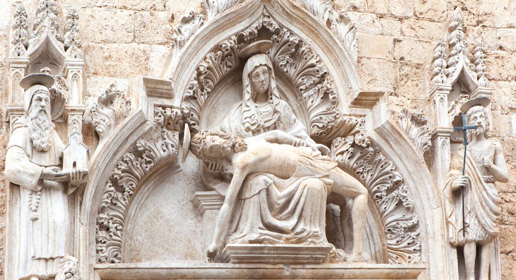Sculptural composition above the gate of the Franciscan monastery of the XIV century. Dubrovnik. Croatia