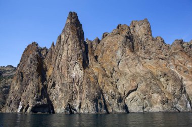 Kara Dag parlak güneş ışığında denizin üzerinde sallanıyor.