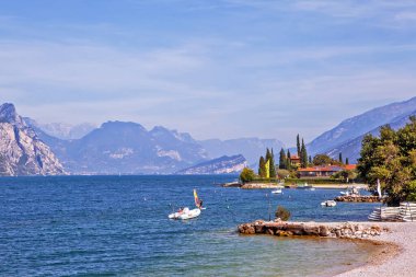 Günışığında kıyıya inşa edilen teknelerle dağlar ve deniz, Sirmione, İtalya