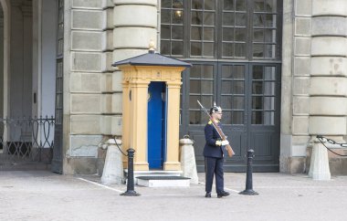 STOCKHOLM, SWEDEN - 3 Eylül 2017: Kraliyet sarayındaki topun yanındaki nöbet yerinde bir gardiyanın fotoğrafı.