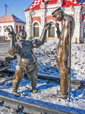 Eski tren istasyonunun arka planına karşı heykel 