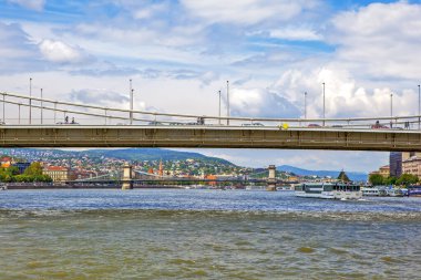 Budapeşte binaları ve nehir üzerindeki köprü bulutlu gökyüzünün altında