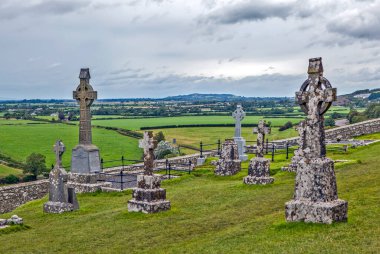KATİGAN, IRELAND - 22 AĞUSTOS 2019: Bir sürü Kelt haçı olan eski bir İrlanda mezarlığının fotoğrafı
