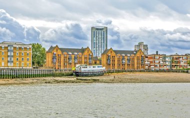 Modern bir mesken ve kıyıda terk edilmiş bir gemi. Londra mı? Birleşik Krallık